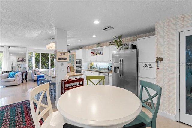 2934 Oceans Trce, Daytona Beach Shores, FL 32118 - dining space with wallpapered walls, a textured ceiling, and recessed lighting