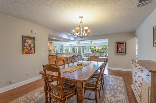 40 Cloverdale Ct N, Palm Coast, FL 32137 - dining area with dark wood finished floors, ceiling fan, a chandelier, baseboards, and a textured ceiling