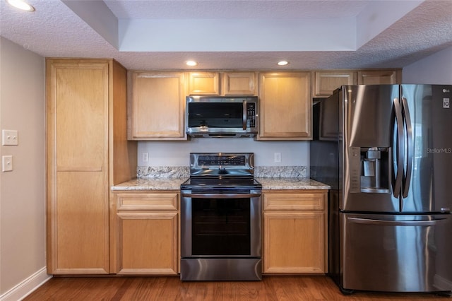 40 Cloverdale Ct N, Palm Coast, FL 32137 - kitchen featuring stainless steel appliances, wood finished floors, a textured ceiling, baseboards, and light stone countertops