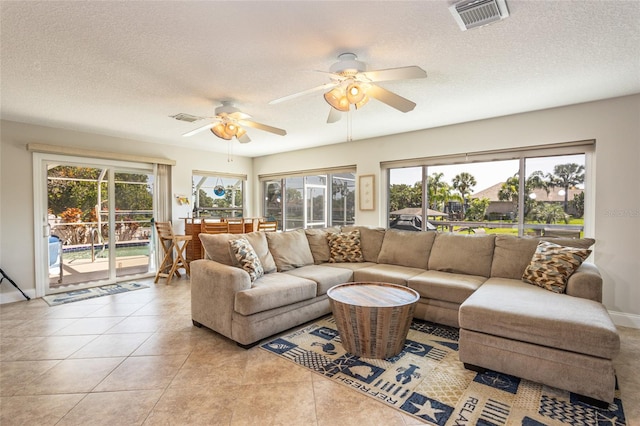 40 Cloverdale Ct N, Palm Coast, FL 32137 - living room with healthy amount of natural light, a textured ceiling, ceiling fan, and light tile patterned floors