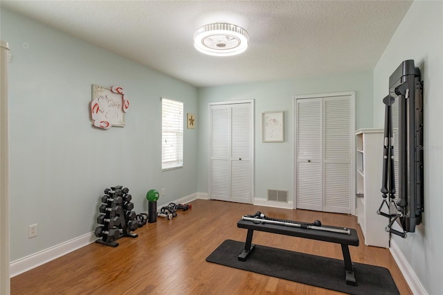 40 Cloverdale Ct N, Palm Coast, FL 32137 - workout area featuring wood finished floors, baseboards, and a textured ceiling