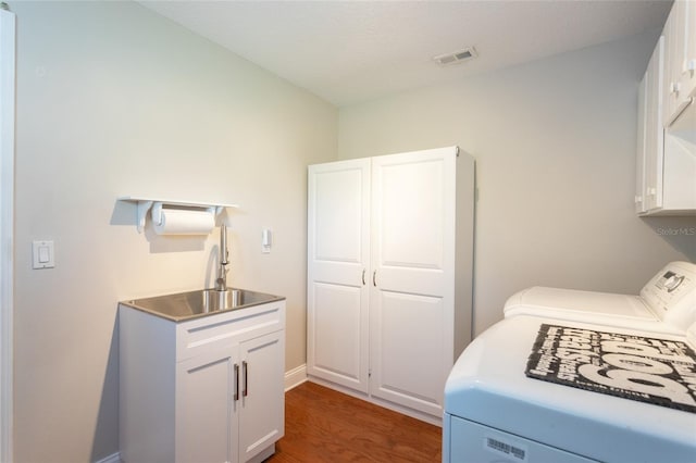 40 Cloverdale Ct N, Palm Coast, FL 32137 - laundry room featuring cabinet space, washing machine and clothes dryer, and dark wood-type flooring