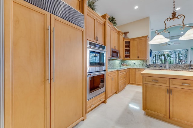 129 Front St, Palm Coast, FL 32137 - kitchen featuring appliances with stainless steel finishes, decorative backsplash, glass insert cabinets, hanging light fixtures, and light stone counters