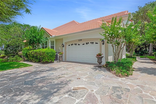 129 Front St, Palm Coast, FL 32137 - view of property exterior featuring a tile roof, driveway, stucco siding, and an attached garage