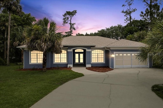 49 Ludlow Ln W, Palm Coast, FL 32137 - ranch-style house featuring driveway, a garage, stucco siding, a yard, and french doors