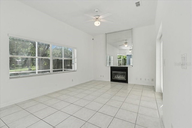 49 Ludlow Ln W, Palm Coast, FL 32137 - unfurnished living room with a ceiling fan, light tile patterned floors, a glass covered fireplace, and baseboards