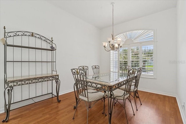 49 Ludlow Ln W, Palm Coast, FL 32137 - dining area with a chandelier, wood finished floors, and baseboards
