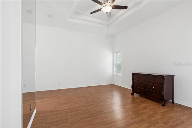 49 Ludlow Ln W, Palm Coast, FL 32137 - spare room with a ceiling fan, a tray ceiling, wood finished floors, and baseboards