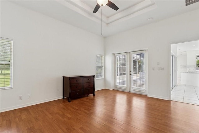 49 Ludlow Ln W, Palm Coast, FL 32137 - empty room featuring wood finished floors, ceiling fan, french doors, baseboards, and a high ceiling