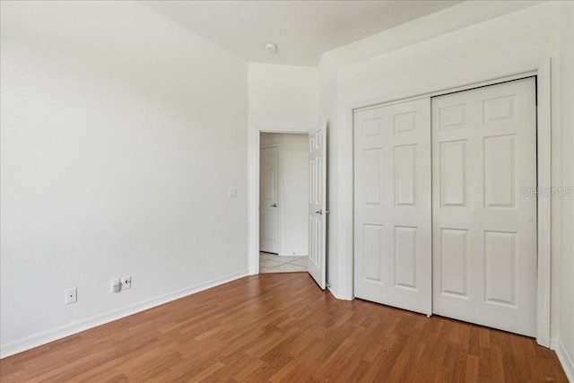 49 Ludlow Ln W, Palm Coast, FL 32137 - unfurnished bedroom with light wood-style flooring, baseboards, and a closet