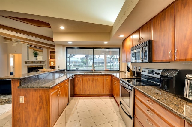 29 Cherrytree Ct, Palm Coast, FL 32137 - kitchen featuring appliances with stainless steel finishes, brown cabinetry, a peninsula, dark stone countertops, and recessed lighting