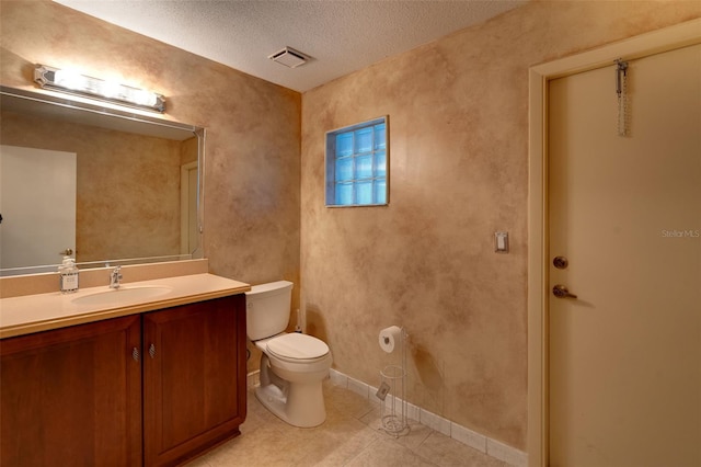 29 Cherrytree Ct, Palm Coast, FL 32137 - bathroom with toilet, vanity, a textured ceiling, tile patterned floors, and baseboards