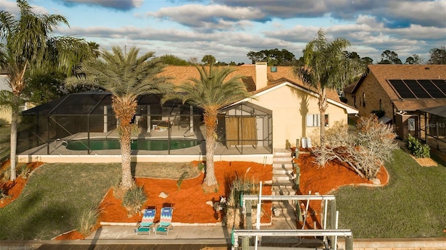 29 Cherrytree Ct, Palm Coast, FL 32137 - back of house with an outdoor pool, a lawn, glass enclosure, and stucco siding