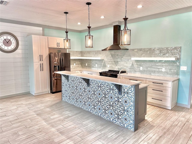 101 Beechers Point Dr, Welaka, FL 32193 - kitchen with stainless steel fridge, wall chimney range hood, light wood-type flooring, a kitchen island with sink, and recessed lighting