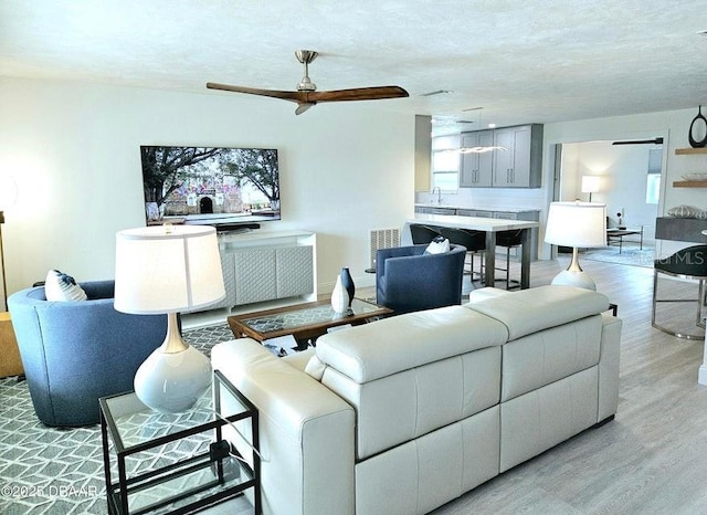 13 Sunrise Ave, Ormond Beach, FL 32176 - living room featuring ceiling fan, light wood-style floors, and a textured ceiling