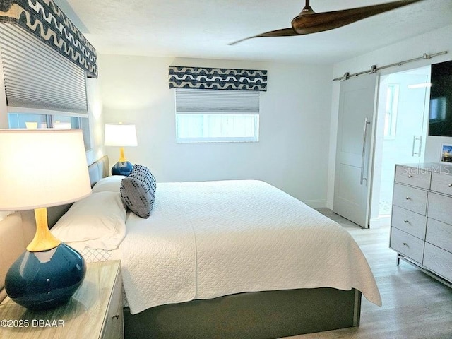 13 Sunrise Ave, Ormond Beach, FL 32176 - bedroom with wood finished floors, a barn door, ceiling fan, and baseboards