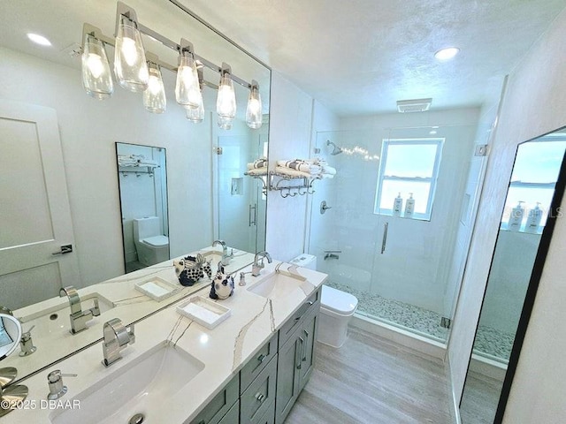 13 Sunrise Ave, Ormond Beach, FL 32176 - bathroom featuring toilet, a stall shower, wood finished floors, and double vanity