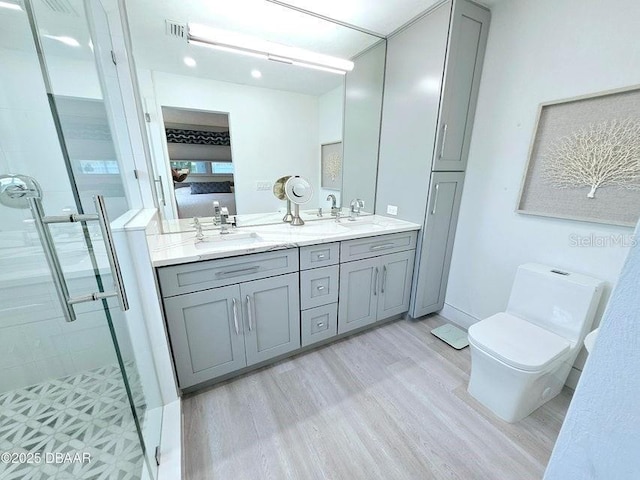 13 Sunrise Ave, Ormond Beach, FL 32176 - bathroom featuring wood finished floors, a stall shower, double vanity, toilet, and recessed lighting