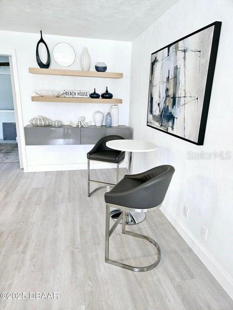 13 Sunrise Ave, Ormond Beach, FL 32176 - dining area with wood finished floors, baseboards, and a textured ceiling
