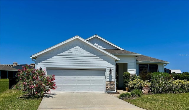 100 Las Casitas Blvd, Palm Coast, FL 32137 - view of front of house featuring driveway, an attached garage, a shingled roof, and stone siding