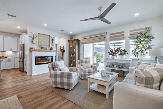 100 Las Casitas Blvd, Palm Coast, FL 32137 - living area with a glass covered fireplace, light wood finished floors, ceiling fan, and recessed lighting