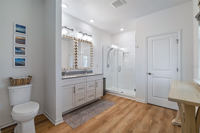 100 Las Casitas Blvd, Palm Coast, FL 32137 - full bath featuring double vanity, wood finished floors, a shower stall, toilet, and recessed lighting