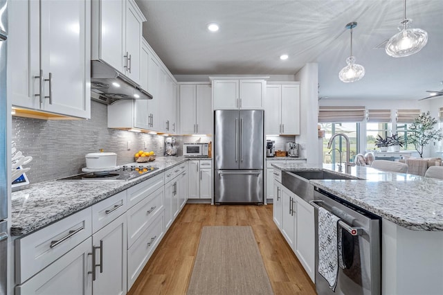 100 Las Casitas Blvd, Palm Coast, FL 32137 - kitchen featuring stainless steel appliances, under cabinet range hood, a sink, white cabinetry, and recessed lighting