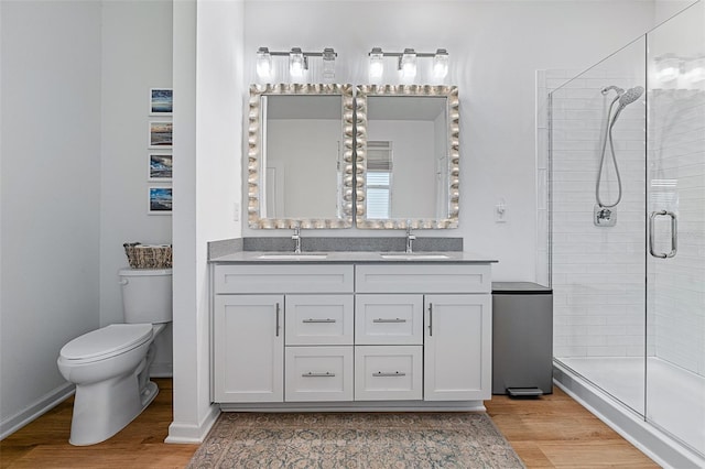 100 Las Casitas Blvd, Palm Coast, FL 32137 - full bathroom featuring wood finished floors, double vanity, a shower stall, and toilet