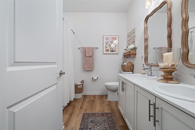100 Las Casitas Blvd, Palm Coast, FL 32137 - bathroom with double vanity, wood finished floors, toilet, and baseboards