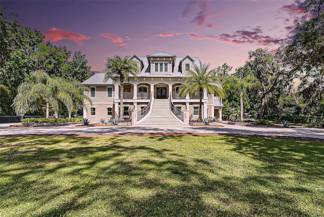140 Monterey Bay Ln, Green Cove Springs, FL 32043 - raised beach house with covered porch, stairway, and a front lawn