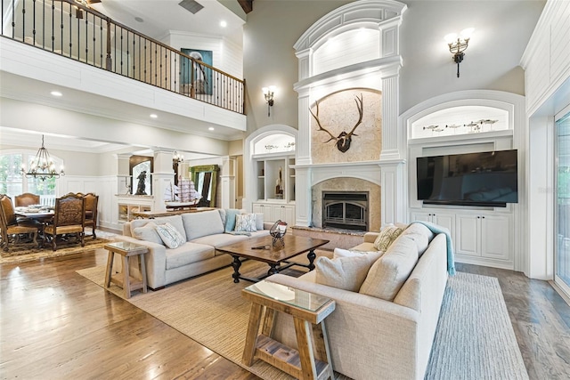 140 Monterey Bay Ln, Green Cove Springs, FL 32043 - living area featuring a high ceiling, wood finished floors, ornate columns, a high end fireplace, and a chandelier