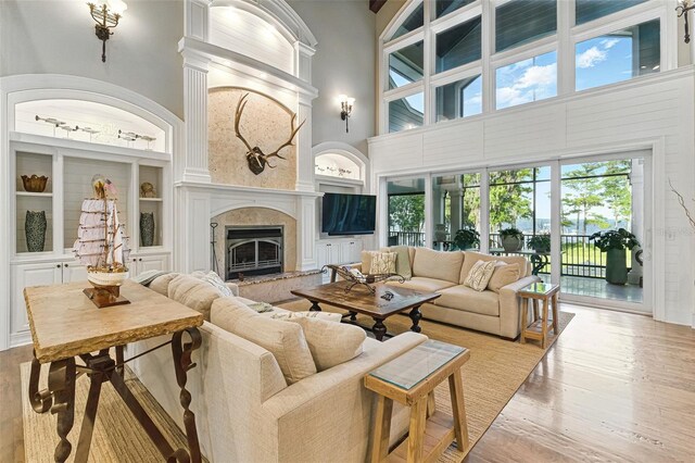 140 Monterey Bay Ln, Green Cove Springs, FL 32043 - living area with built in shelves, a high ceiling, wood finished floors, and a premium fireplace