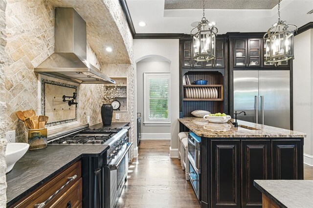 140 Monterey Bay Ln, Green Cove Springs, FL 32043 - kitchen featuring exhaust hood, premium appliances, dark wood-style flooring, arched walkways, and recessed lighting