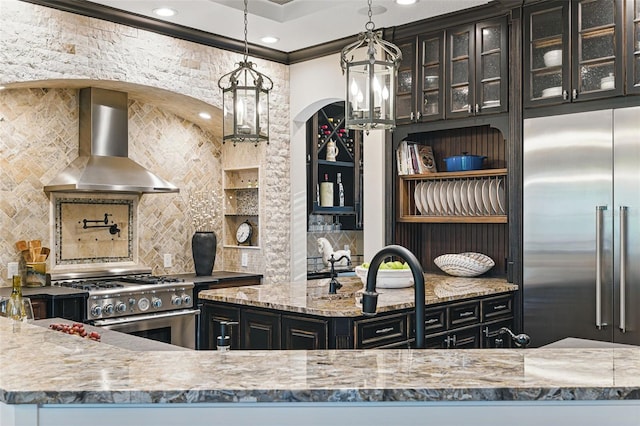 140 Monterey Bay Ln, Green Cove Springs, FL 32043 - kitchen with wall chimney range hood, high quality appliances, light stone counters, tasteful backsplash, and arched walkways