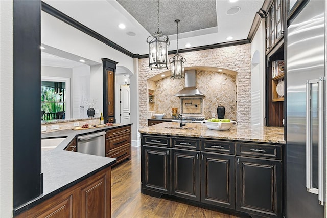 140 Monterey Bay Ln, Green Cove Springs, FL 32043 - kitchen featuring appliances with stainless steel finishes, ornamental molding, wall chimney range hood, decorative columns, and decorative backsplash