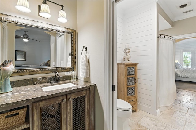 140 Monterey Bay Ln, Green Cove Springs, FL 32043 - ensuite bathroom featuring stone tile floors, vanity, toilet, a ceiling fan, and crown molding