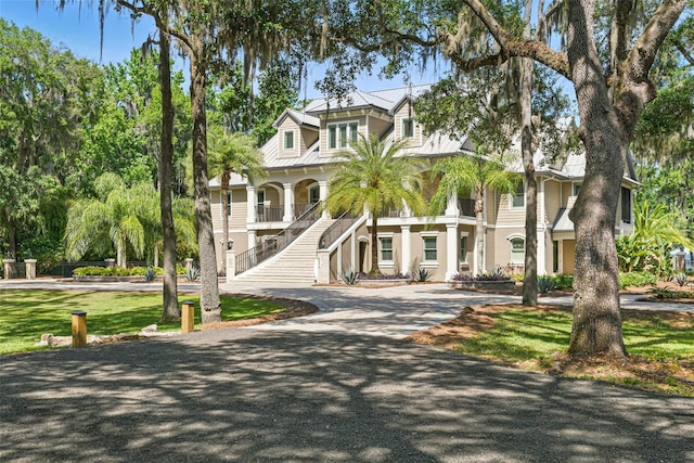 140 Monterey Bay Ln, Green Cove Springs, FL 32043 - raised beach house with stairs, driveway, a porch, stucco siding, and metal roof