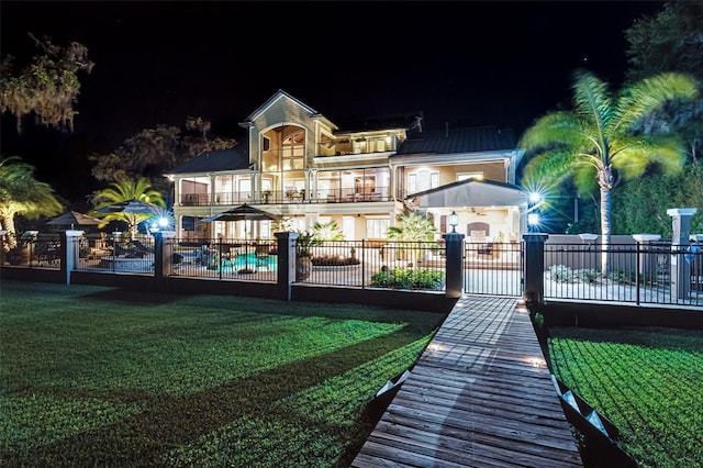 140 Monterey Bay Ln, Green Cove Springs, FL 32043 - back of house at night featuring a balcony and a gate