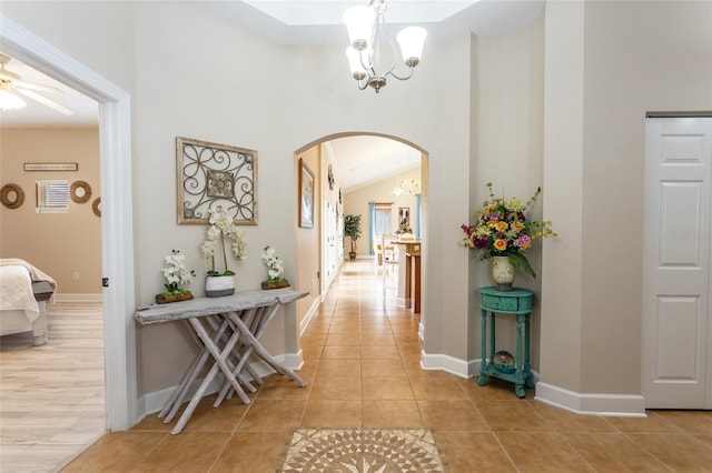 200 Bella Harbor Ct Unit 113, Palm Coast, FL 32137 - corridor featuring a chandelier, arched walkways, light tile patterned floors, a high ceiling, and baseboards