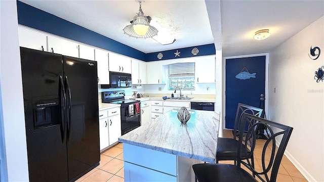 1640 Juno Trl Unit 202E, Astor, FL 32102 - kitchen with black appliances, light tile patterned floors, a sink, a breakfast bar area, and a center island
