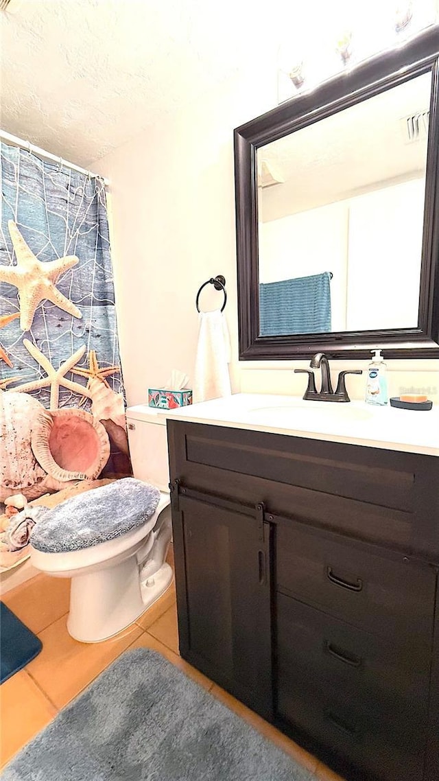 1640 Juno Trl Unit 202E, Astor, FL 32102 - full bath with vanity, tile patterned floors, toilet, a textured ceiling, and a shower with shower curtain