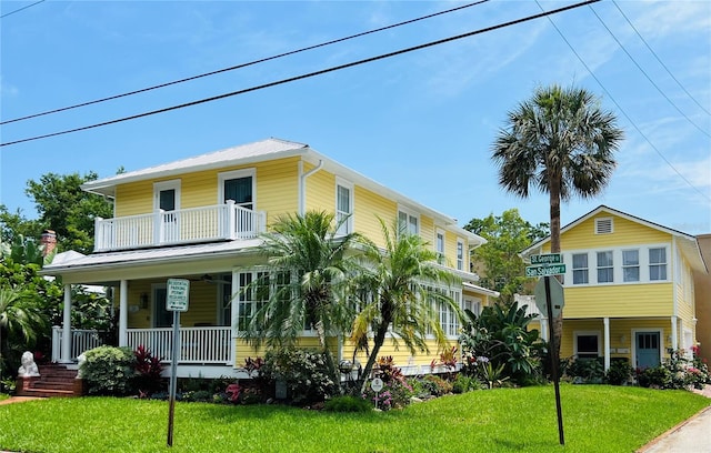 317 Saint George St, Saint Augustine, FL 32084 - view of front of home featuring covered porch, a front yard, metal roof, and a balcony