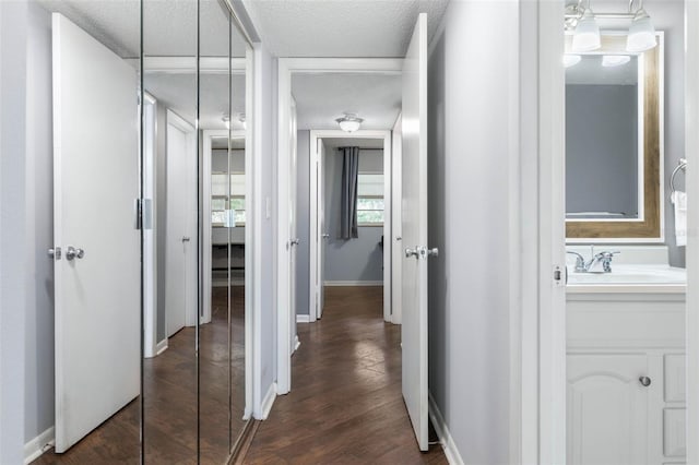 640 N Nova Rd Unit 117, Ormond Beach, FL 32174 - hallway featuring dark wood-style floors, a sink, baseboards, and a textured ceiling