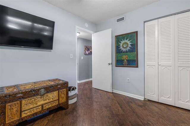 640 N Nova Rd Unit 117, Ormond Beach, FL 32174 - bedroom with wood finished floors, a closet, baseboards, and a textured ceiling