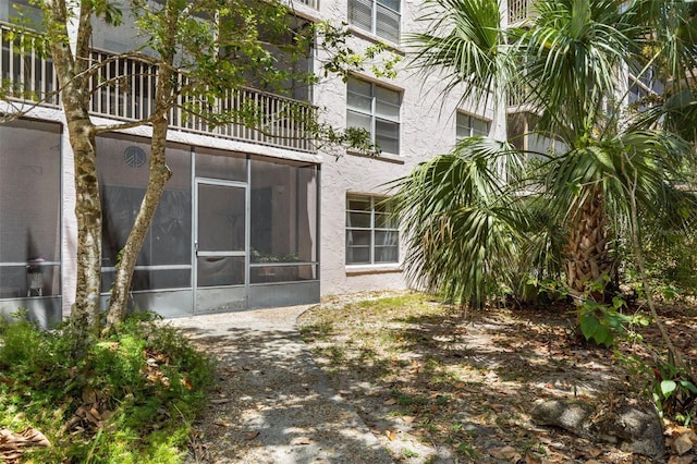 640 N Nova Rd Unit 117, Ormond Beach, FL 32174 - back of house featuring a sunroom, stucco siding, and a balcony