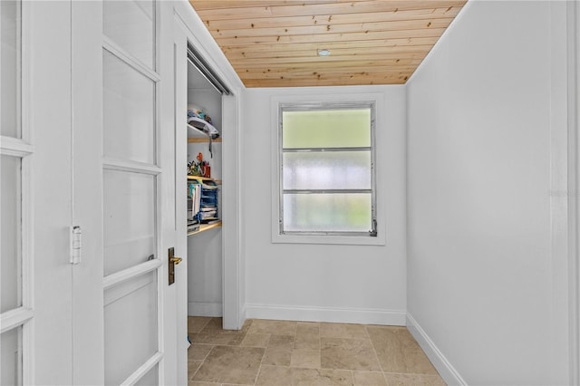 129 Dundee Rd, Daytona Beach, FL 32118 - hallway with wood ceiling, baseboards, and light stone finish flooring