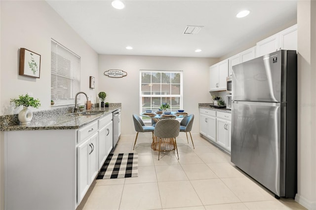 217 Birchwood Dr, Palm Coast, FL 32137 - kitchen with appliances with stainless steel finishes, a sink, dark stone countertops, white cabinetry, and recessed lighting