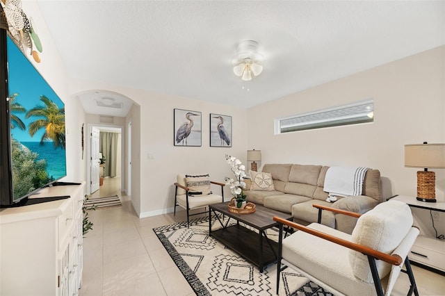 217 Birchwood Dr, Palm Coast, FL 32137 - living area with arched walkways, ceiling fan, light tile patterned flooring, and baseboards