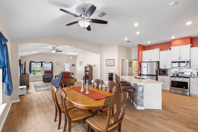 65 Lob Wedge Ln, Bunnell, FL 32110 - dining room featuring a ceiling fan, arched walkways, light wood finished floors, vaulted ceiling, and recessed lighting