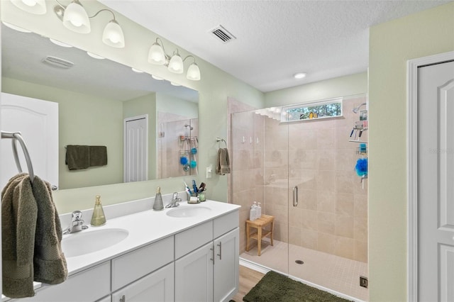 65 Lob Wedge Ln, Bunnell, FL 32110 - bathroom featuring a shower stall, double vanity, wood finished floors, and a textured ceiling